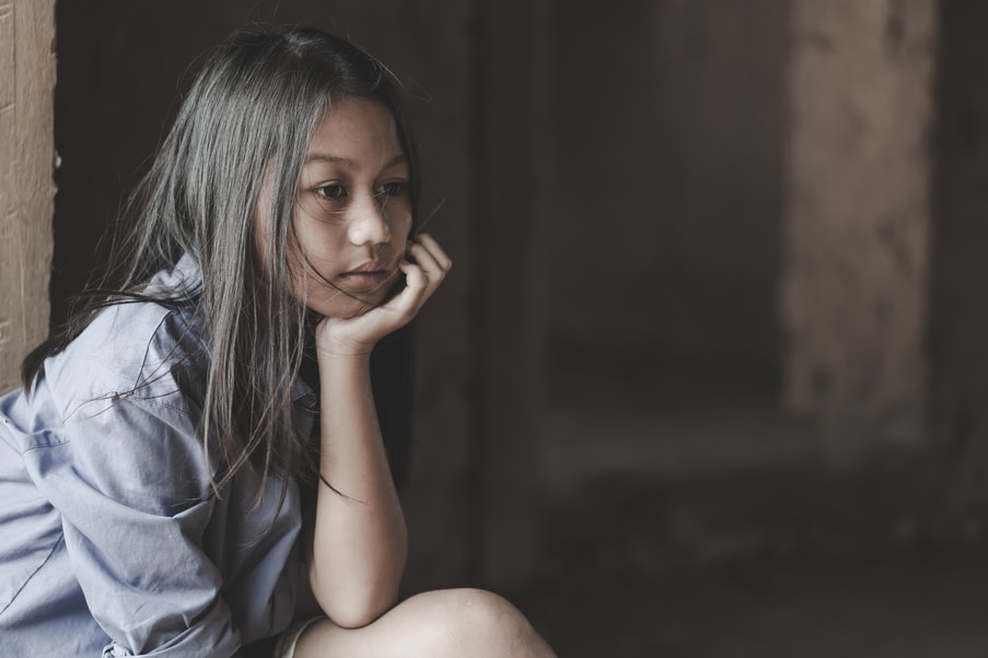 Young girl with her chin resting on her hand thinking