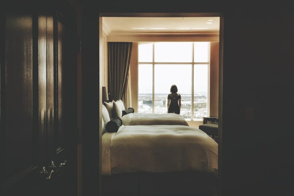 Back of woman sitting on hotel bed