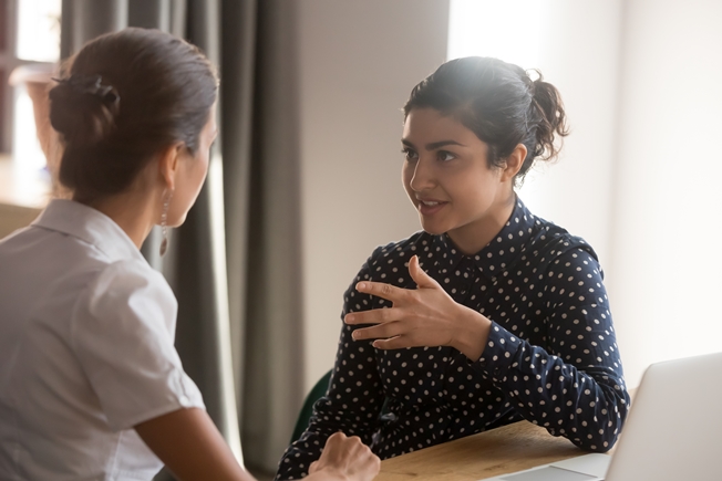 A woman speaking with a social worker