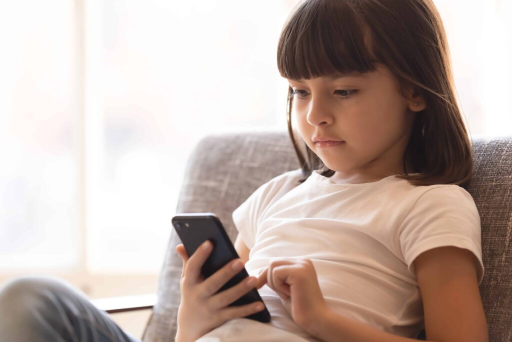 Little girl looking at her phone