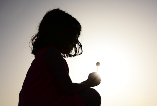 Silhouette of child holding a flower