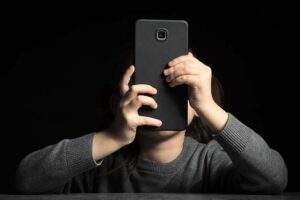 Child holding a smartphone in front of their face