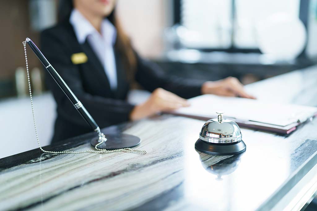 Hotel staff person behind check in desk